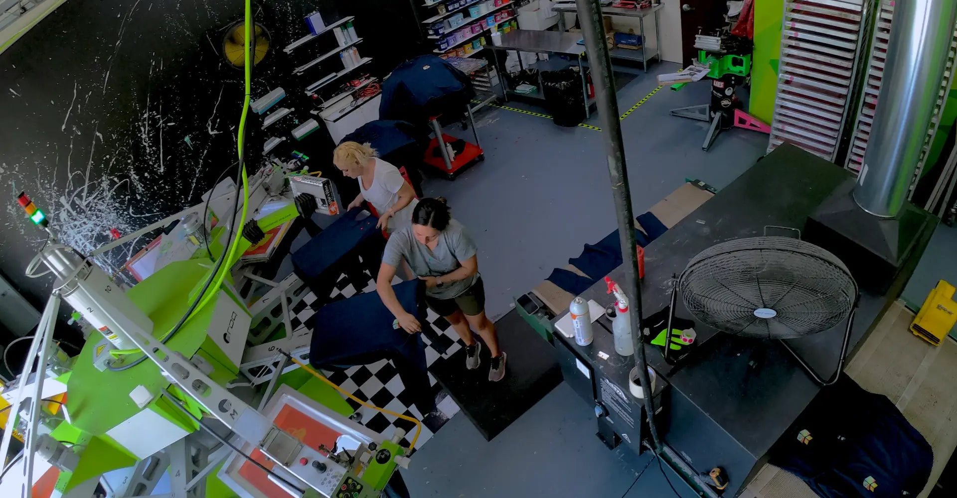 High-angle view of a workshop with tools and equipment on shelves and workbenches. Loveus Brand screen printing custom shirts in Raleigh North Carolina