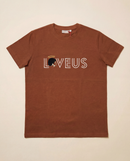 A front view of the brown Loveus Caramel Angel tee against a neutral beige background, showcasing the relaxed structured fit and prominent chest graphic.