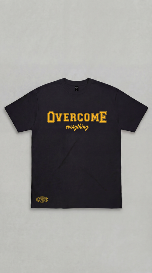 A close-up studio shot of the black Overcome Everything graphic tee against a gray backdrop, showcasing the premium textured look of the raised HD rubberized print.