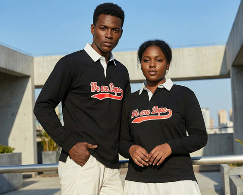 A Black man and a Black woman confidently posing together outdoors in formal clothing, showcasing the black Loveus We Are Dope Cursive Rugby Polo with its distinct white collar.