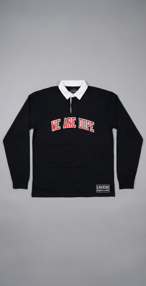 A long-sleeve black We Are Dope Heavyweight Rugby Polo displayed against a clean gray background, showcasing the premium cotton texture and cursive tackle twill design.